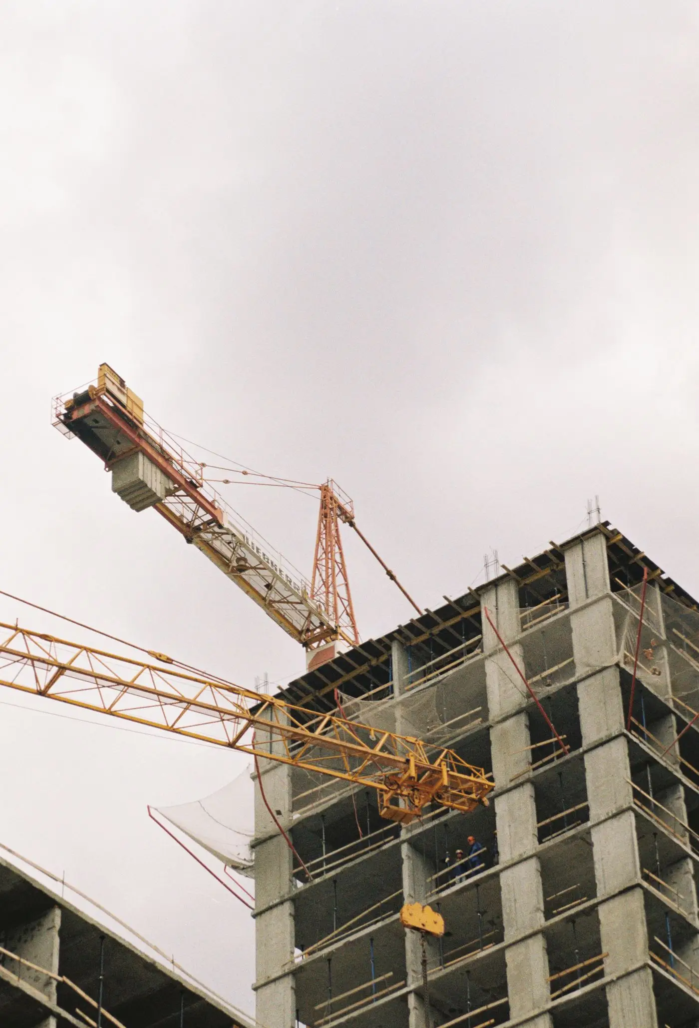 Tower cranes over a building under construction.