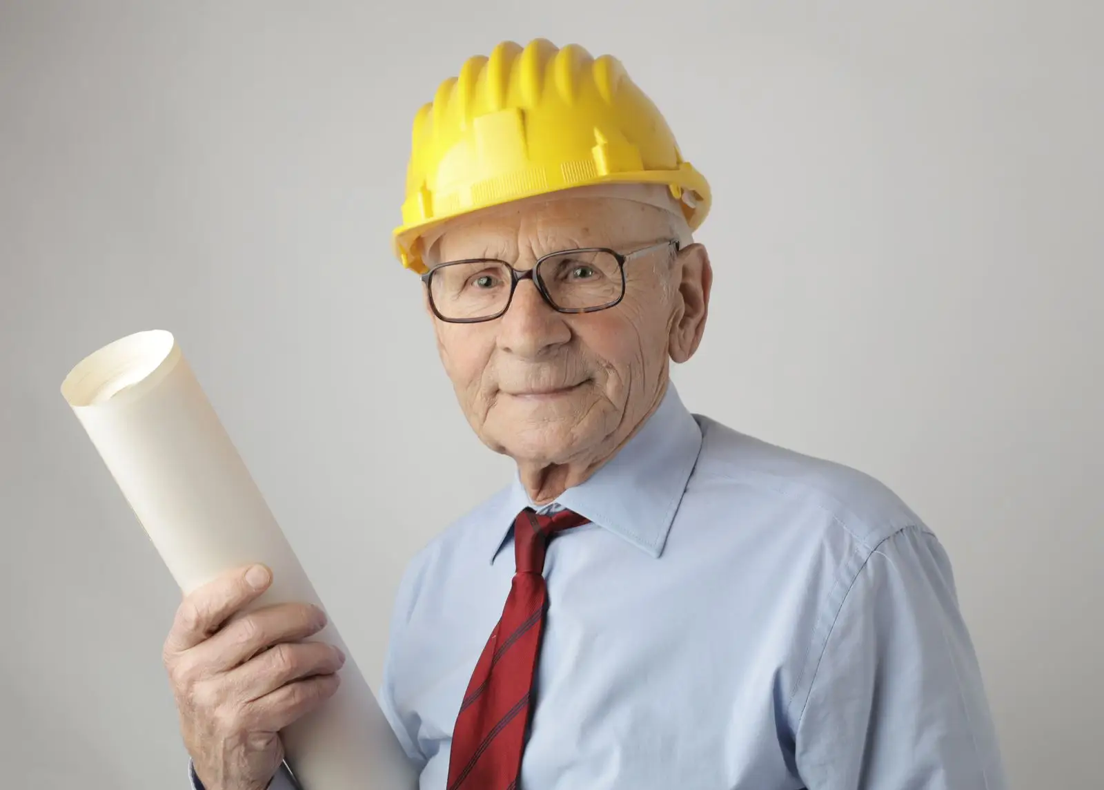 Engineer in a hard hat holding plans.
