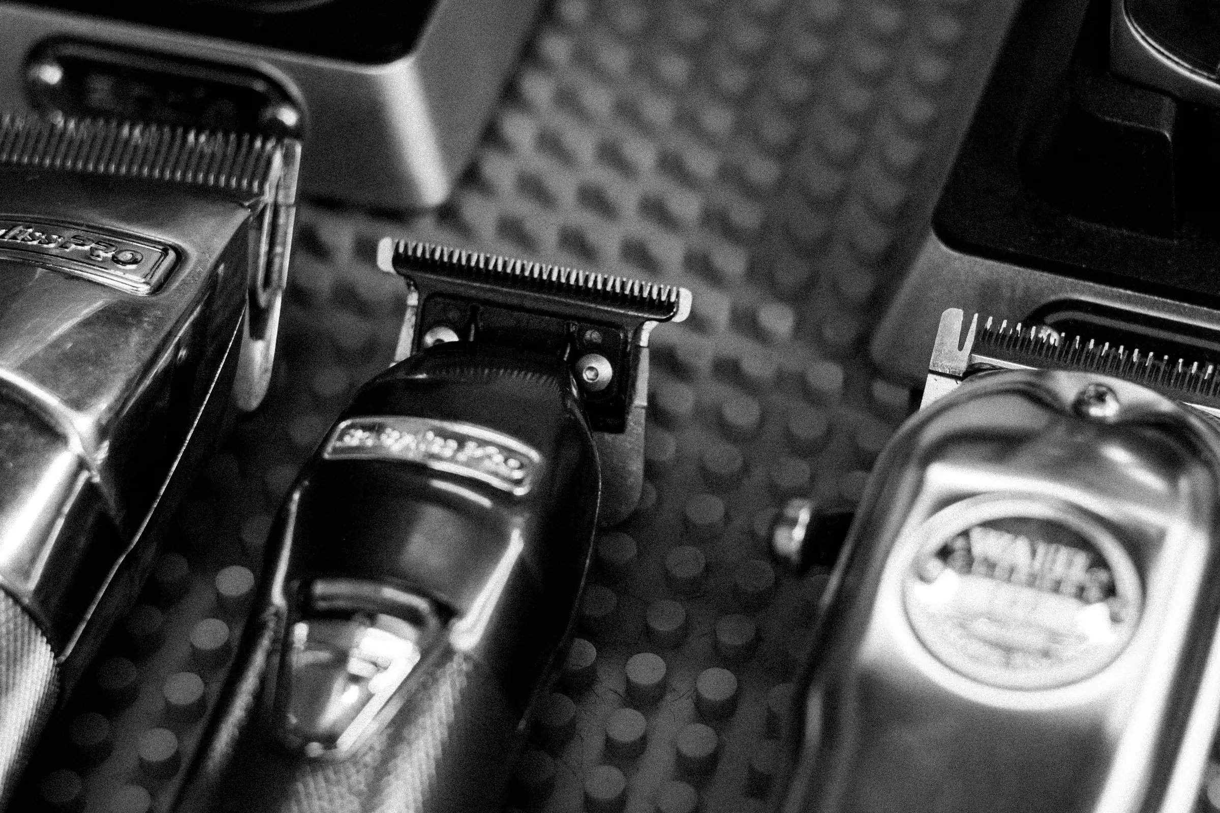 Professional clippers on a textured surface, in black and white.