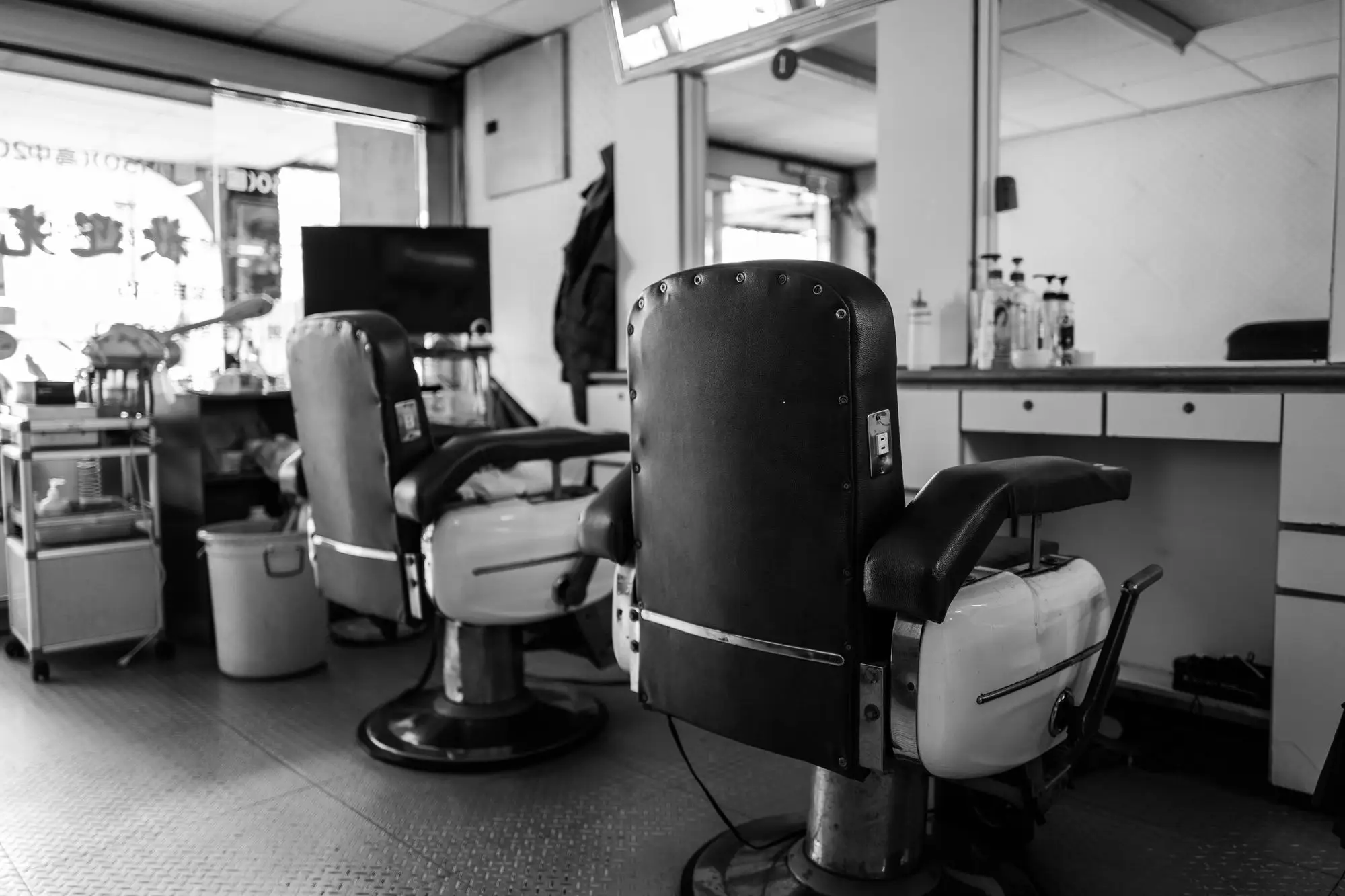 Inside the barbershop: classic chairs and mirrors, in black and white.