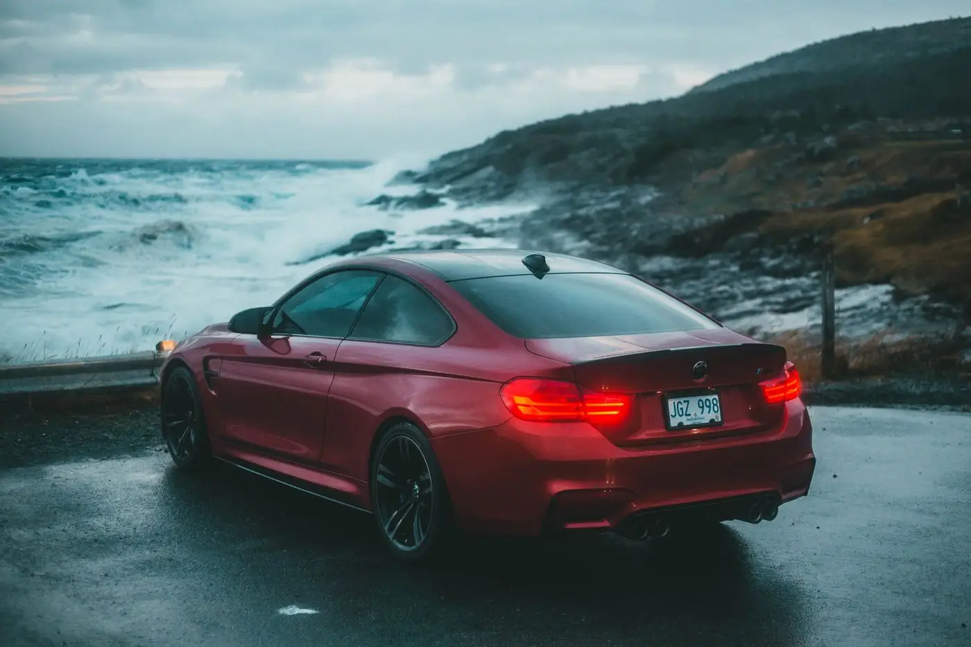 Red sports car by the ocean.