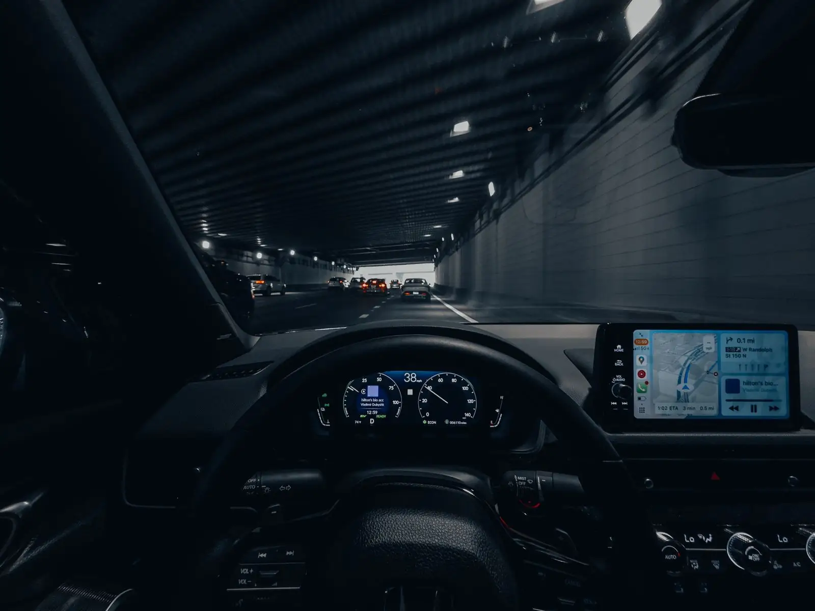 Driving through a lit city tunnel at night.