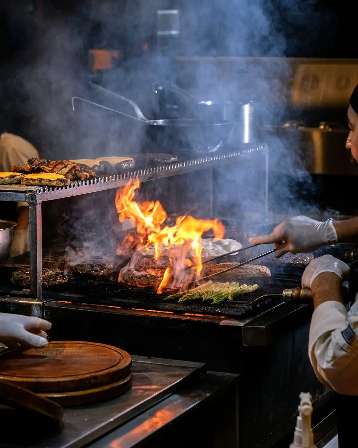 Cooks working the grill in a busy kitchen.